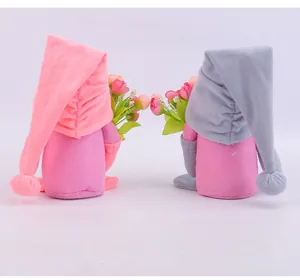 Back view of soft plush gnomes holding colorful tulip bouquets for home decoration