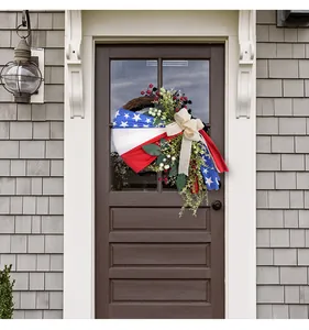 Patriotic Independence Day wreath with American flag ribbon on a front door.