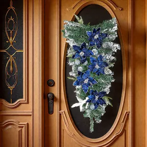 Elegante kerst teardrop swag met blauwe fluwelen kerststerren en besneeuwde dennentakken