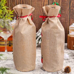 Two rustic burlap Christmas wine bottle covers with red ribbons for holiday table decor