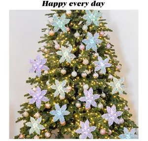 Detail view of macaron colored Christmas flowers decorating a festive tree with lights