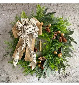 Rustikaler Weihnachtskranz Detail mit Tannenzapfen, goldenen Glocken und Schleife