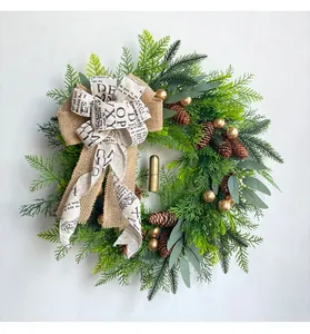 Detailansicht eines Weihnachtskranzes mit Tannenzapfen und goldenen Glocken