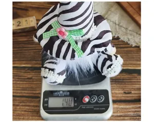 Handmade zebra print gnome plush doll weight measurement on high precision digital scale