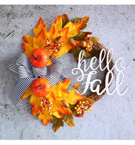 Vista detallada de una corona de otoño con hojas de arce y decoración hello Fall