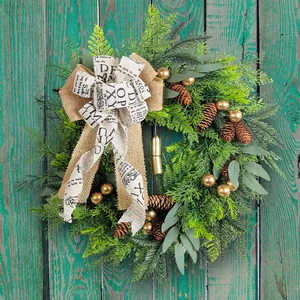 Rustikaler Weihnachtskranz mit Zapfen, Glocken und Sackleinen-Schleife für die Tür