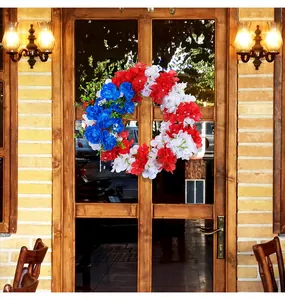 Ghirlanda di fiori artificiali rossa bianca blu patriottica su una porta di legno