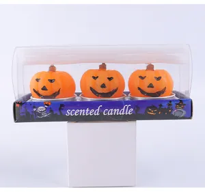 Detailed view of three orange Halloween pumpkin scented candles in a festive gift box
