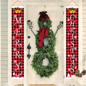 Red and black plaid Christmas door banners hung on a white door with a festive wreath.