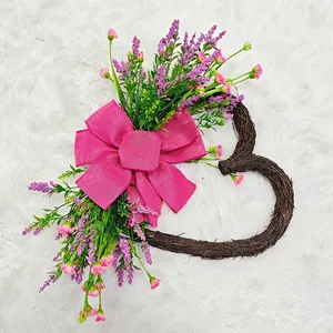 Macro view of heart-shaped twig wreath with pink burlap bow and artificial flowers