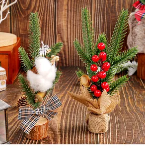 Gros plan de mini sapins de Noël de 25 cm avec capsule de coton et baies rouges en décor rustique