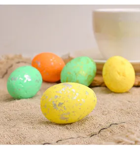 Macro detail of colorful foam Easter eggs with silver foil speckles on burlap