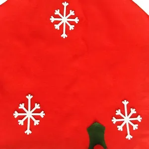 Vue détaillée du motif flocon de neige blanc sur la housse de chaise de Noël en tissu rouge.
