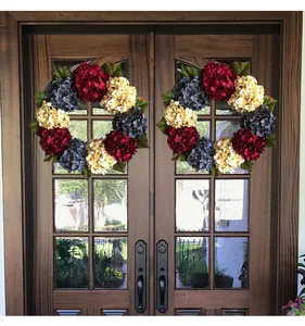 Decorative red white and blue hydrangea wreaths hanging on a wooden double door