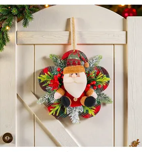 Gros plan d'une couronne de Noël festive avec le Père Noël sur une porte en bois blanc.