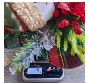 Décoration de table de Noël festive pesée sur une balance, affichant un poids de 191g.