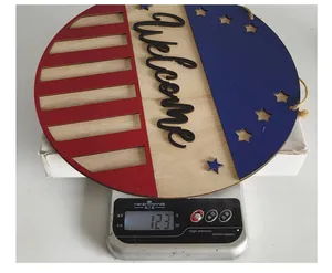Detailansicht eines patriotischen Türhängers aus Holz, der auf einer Waage 123 Gramm wiegt.