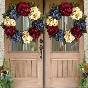 Patriotic red white and blue hydrangea wreaths hanging on wooden front doors