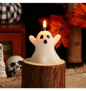 Lit white ghost shaped candle on a natural wooden log for Halloween table decoration