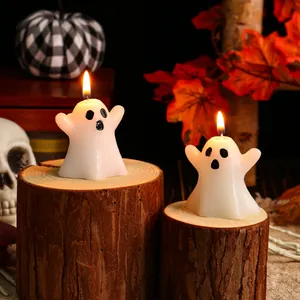 Cute ghost shaped Halloween decorative candles on rustic wooden stands for ambiance