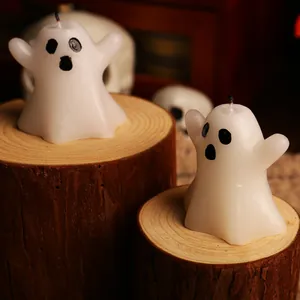 Cute white Halloween ghost candles on rustic wooden pedestals for spooky party decor