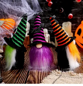 Detail of three Halloween gnomes with colorful striped wizard hats on wooden table