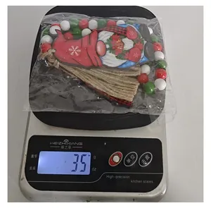 Gewichtsangabe für eine Weihnachtsgnom-Deko mit roten, weißen und grünen Holzperlen