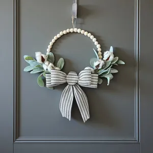 Vue détaillée d'une couronne de perles artisanale avec un nœud rayé et des fleurs de coton