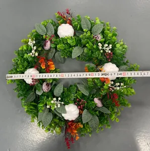 Detailed view of artificial autumn eucalyptus wreath with white pumpkins and measuring tape