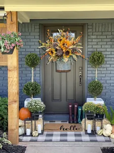 Autumn harvest festival door basket with sunflowers and pine cones on a front porch