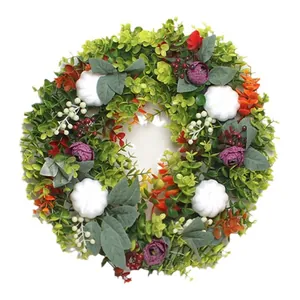 Artificial fall eucalyptus wreath with white pumpkins and purple flowers for autumn decor
