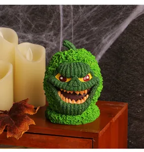 Detalle de adorno de calabaza monstruo verde para decoración de mesa de fiesta Halloween