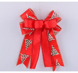 Detail of red double-layered Christmas bow with gold glitter edge and tree pattern