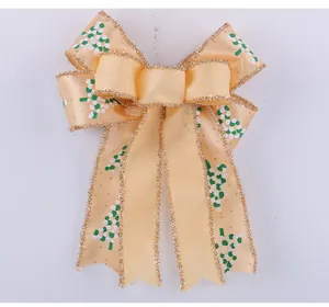 Detail showing the champagne gold Christmas bow with glitter edges and leaf prints