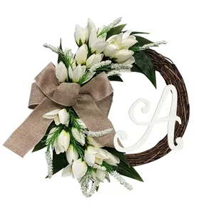 Elegante witte tulpen wijnstok krans met jute strik en decoratieve witte letter A
