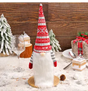 Detailed view of a knitted Christmas gnome wine bottle cover in a festive scene.