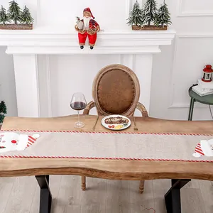 Christmas burlap table runner with Santa Claus motif on rustic wooden dining table