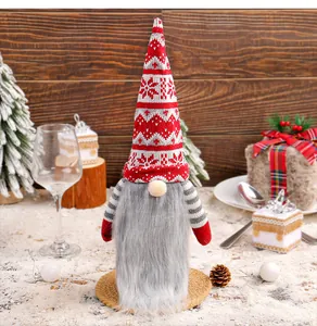 Detail of a handmade faceless Christmas gnome with red knitted hat and long grey beard.