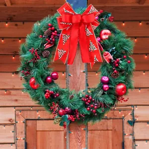 Large festive Christmas wreath with a red double-layer bow and pine cone berry accents