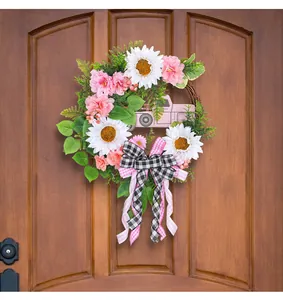 Ghirlanda floreale decorativa con camion rosa e girasoli bianchi su porta legno