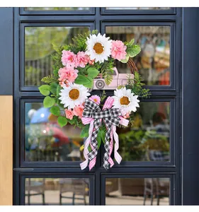 Dettaglio di una ghirlanda floreale con camion rosa, girasoli e fiocco a scacchi