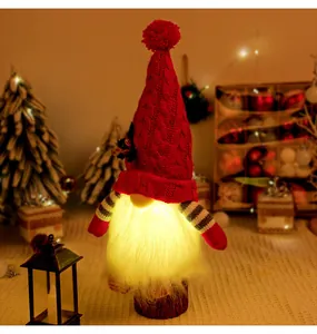 Detailed view of a glowing Christmas gnome plush with a red knitted hat and LED beard.