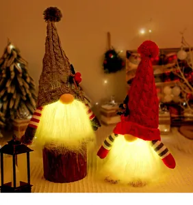 Detail view of two glowing Christmas gnomes with warm LED light in a festive room