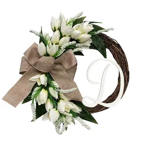 Decoratieve krans voor de voordeur met witte tulpen jute strik en houten letter D detail