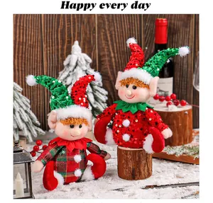 Close-up of two cute Christmas elf dolls with shiny sequin hats in a festive snow scene