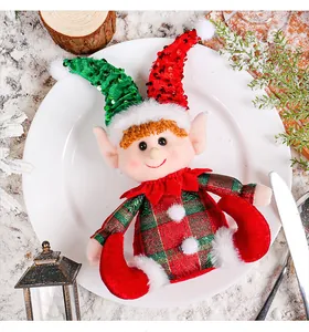 Close-up of a Christmas elf doll with red and green sequined hats on a festive plate.