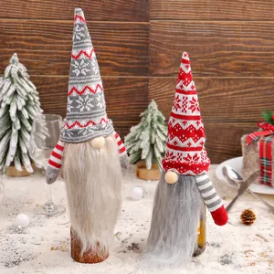 Two knitted Christmas gnome wine bottle covers for festive holiday tabletop decoration