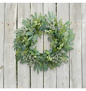 Artificial eucalyptus wreath with green berries hanging on a rustic wooden background