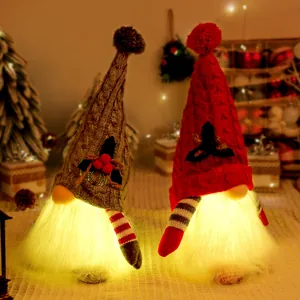 Pair of glowing Christmas gnomes with grey and red knitted hats for holiday decor