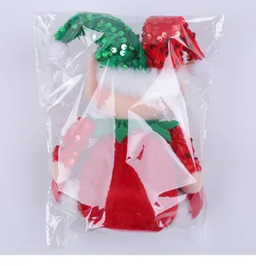 Detailed back view of a Christmas elf plush doll with sequined hat inside clear plastic packaging